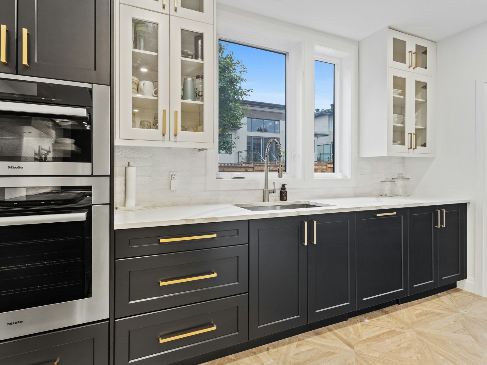 Finished kitchen with dark lower cabinets, white uppers and quartz countertops